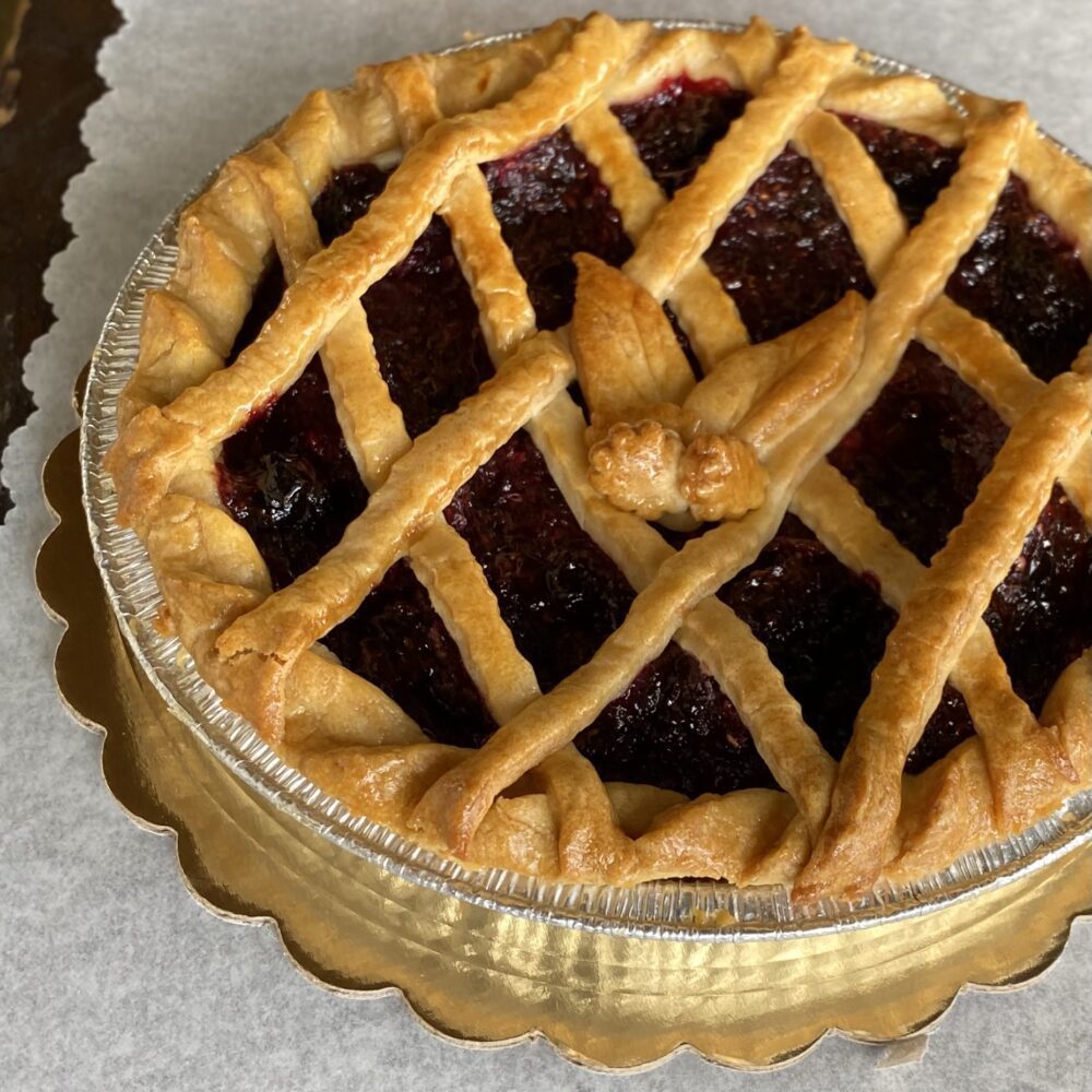 Side view of a mixed berry pie on a table.