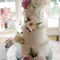 Three-tier textured wedding cake with floral placement.