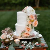 Two-tier rustic style wedding cake with flower placement.