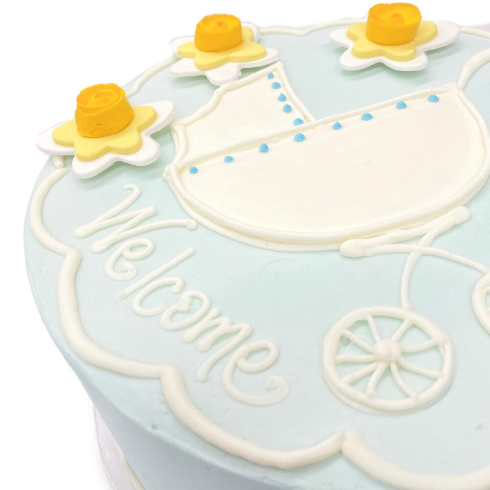 Detail of Baby Carriage decoration on a round cake frosted in blue buttercream.