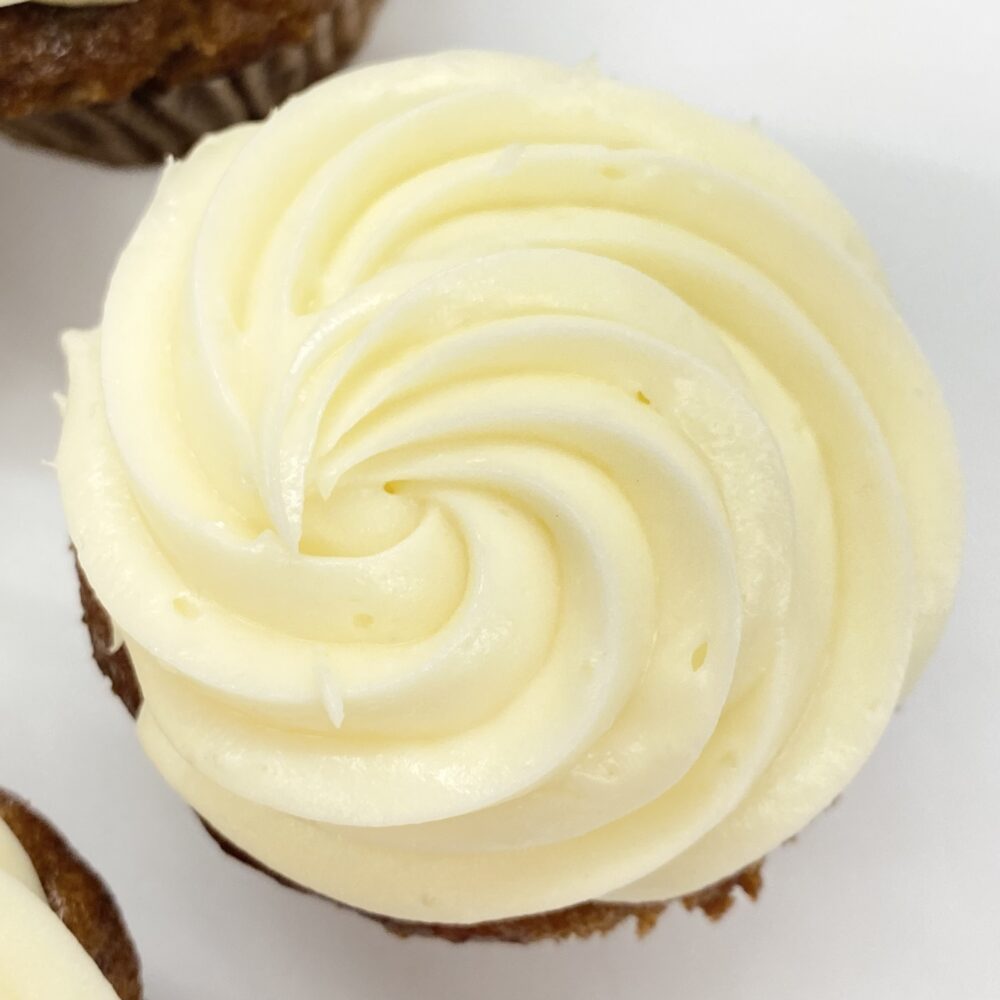 Top view of carrot cake cupcake with cream cheese frosting in Star-tip style.