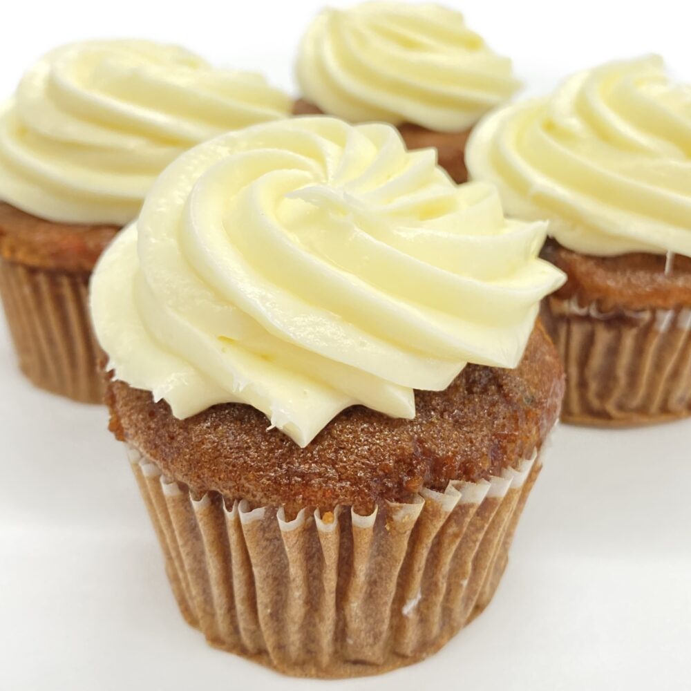 Side view of carrot cupcakes with cream cheese frosting.