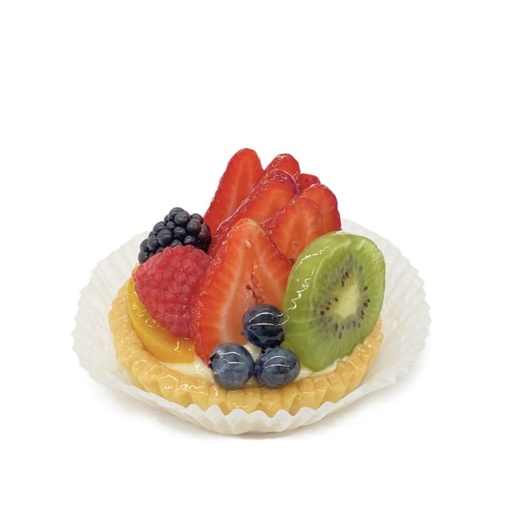 Side view of individual sized fresh fruit tart.
