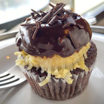Side view of German Chocolate Cupcake on plate with fork.