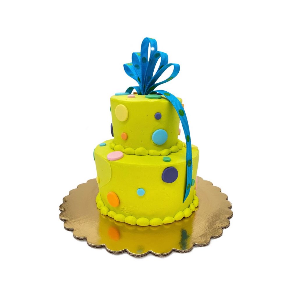 Itty Bitty Birthday cake in chartreuse with a blue ribbon and assorted dots.