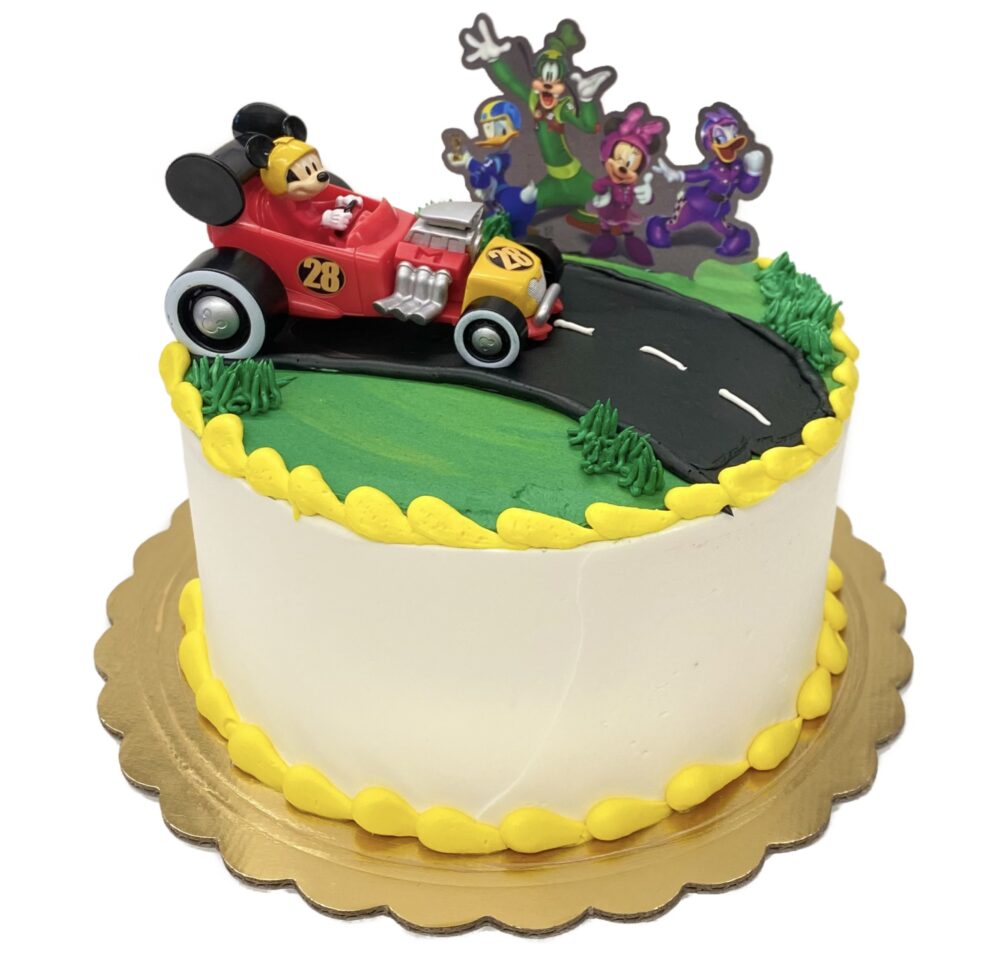 Side view of the Mickey Racecar decoration on a white buttercream frosted cake.