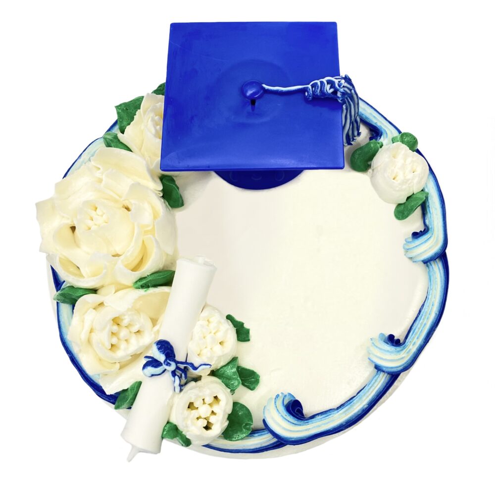 Top view of Roses Graduation decoration on round cake frosted in white buttercream with blue details.