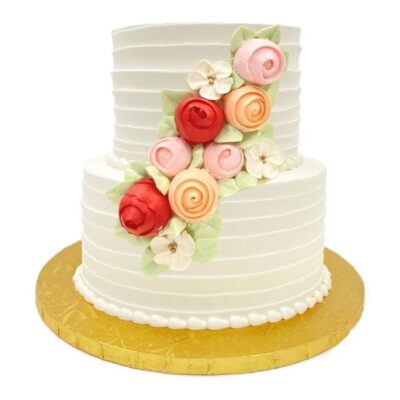 Example of two-tiered horizontal style cake in white buttercream with roses cascade decoration.
